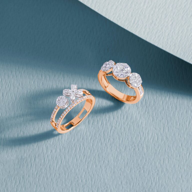 Close-up of luxurious diamond rings on a textured blue surface, showcasing elegance and craftsmanship.